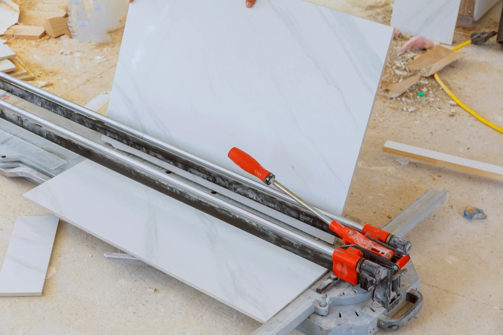 Ręczna przecinarka do płytek ceramicznych podczas cięcia białej płytki, usługa Glazura