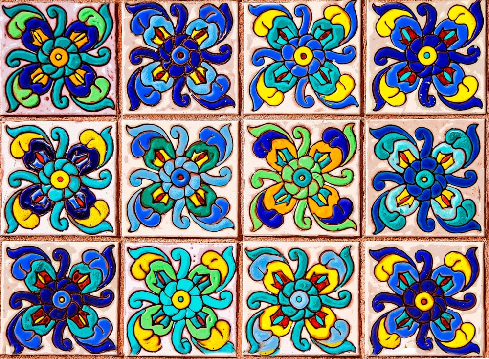Kolorowa glazura z kwiatowym wzorem ułożona w regularną siatkę na ścianie